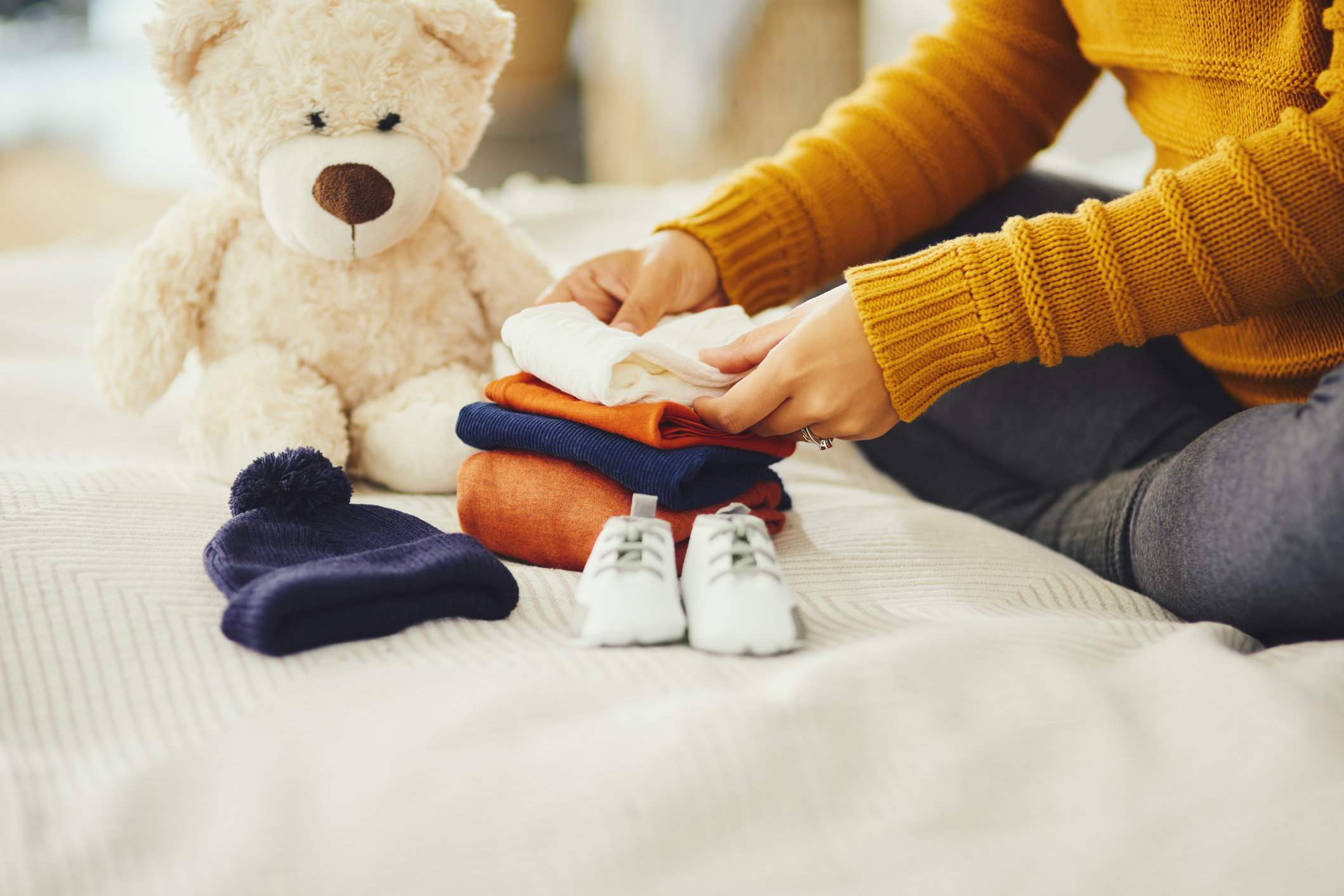 Shot of an unrecognizable pregnant woman sorting out baby clothes in her bedroom at at home